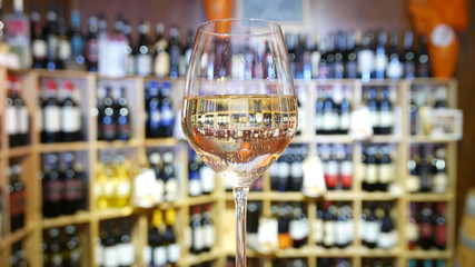 White wine glass in an Italian wine bar. - obrazy, fototapety, plakaty