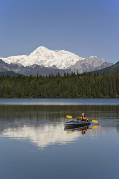 Man Paddling A Klepper Kayak On Byers Lake At Denali State Park. Mt. Mckinley Is Visible In The Background. August. Summer In The Interio Of Alaska.