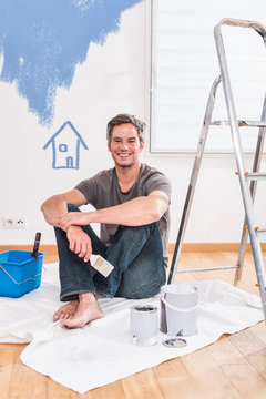  handsome gray haired man painting walls of his new home