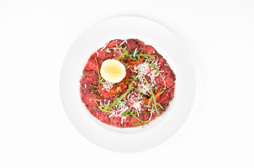 Carpaccio on a plate on a white background, top view