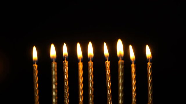 Footage golden burning candles set on black background. 4K