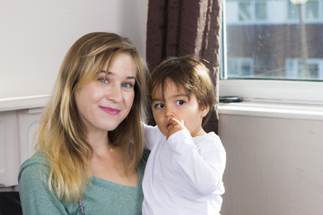 Young woman holding son on arms