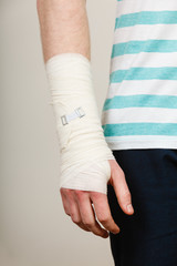 Part body man with bandaged hand.