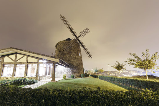 Aixerrota windmill in Getxo, Basque Country, Spain. At night with a cloudy sky. Wide angle shot.