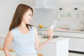 部屋で水を飲む女性