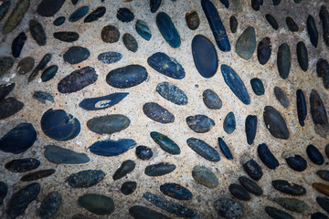 cobblestones in concrete background, Round stones in the ground.