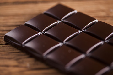Chocolate bar, candy sweet, dessert food on wooden background