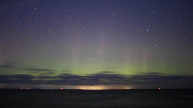Time lapse night sky, Big Dipper Ursa Major Constellation moving with green and red light pillars from Northern Light in Ontario, Canada