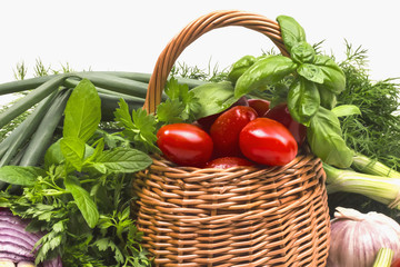 basket with small tomatoes and fresh aromatic herbs