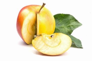 cut piece of juicy ripe red yellow apple with green leaves close