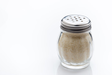 Shaker jar with Parmesan cheese on white background.