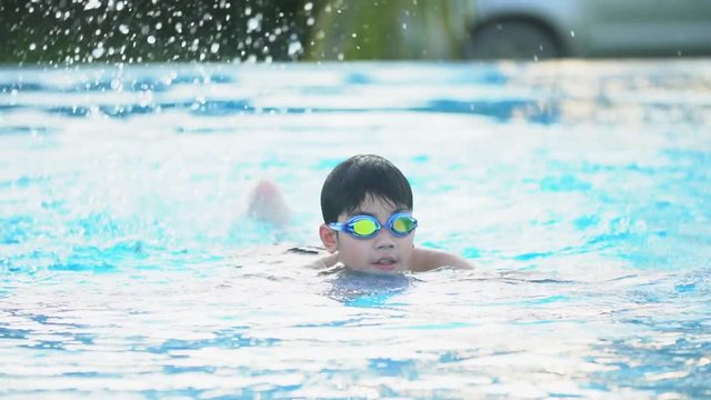 Slow motion of asian child playing in pool, Happy boy having fun on vacation.