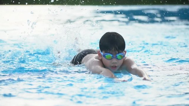 Slow motion of asian child playing in pool, Happy boy having fun on vacation.