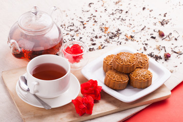 Chinese mid autumn festival foods. Traditional mooncakes on table setting with teacup.