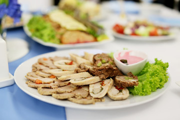 plate with cold meats on a festive table