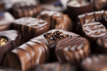 Chocolate bars and pralines on wooden background