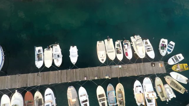 Small boats docked in harbor aerial motion view