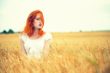 Fototapeta na wymiar Beautiful redhead girl at meadow 