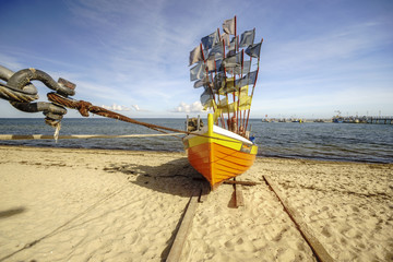 Drewniana,kolorowa łódź rybacka na plaży Morza Bałtyckiego
