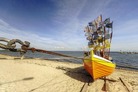 Fototapeta Drewniana,kolorowa łódź rybacka na plaży Morza Bałtyckiego  