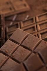 Dark homemade chocolate bars and cocoa pod on wooden