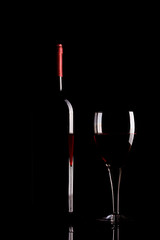 Red wine glass and bottle silhouette isolated on black background