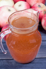 fresh squeezed apple juice in the pitcher on wooden table