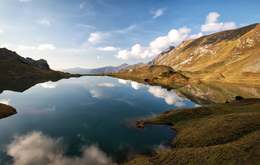 Fototapeta na wymiar alpine lake with reflected blue sky