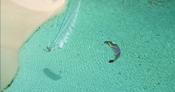 Aerial view young man kitesurfing in tropical blue ocean, extreme sport