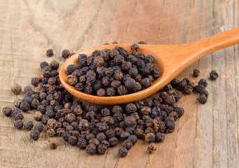 Black pepper corn on wooden scoop