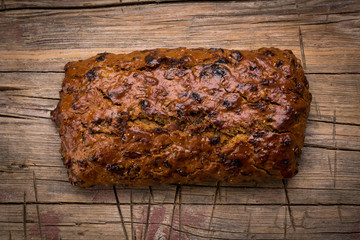 Laib Früchte Brot auf verwittertem Holz Hintergrund.