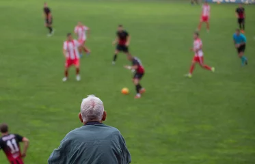 Tuinposter Old man watching football © Budimir Jevtic