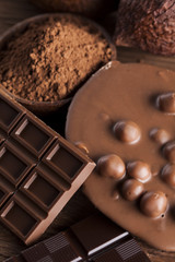 Chocolate bar, candy sweet, cacao beans and powder on wooden bac