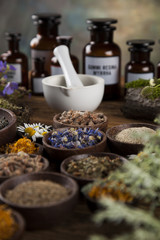 Healing herbs on wooden table, mortar and herbal medicine