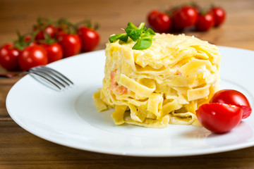close-up of plate of pasta and smoked salmon with tomato