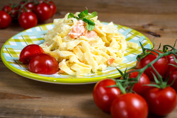 close-up of plate of pasta and smoked salmon with tomato