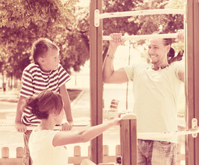  parents with child  training with pull-up bar