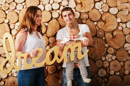 Young caucasian happy family  background wooden stump wall with