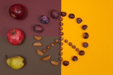 Peace symbol of nuts and autumn fruits on split background