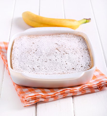 Banana pudding in a tin  with icing sugar
