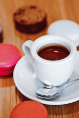 A beautiful  colorful macaroons and a Cup of hot chocolate on wooden background