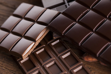 Dark homemade chocolate bars and cocoa pod on wooden