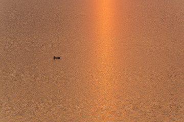 water surface on the lake, sunset reflection and lonely boat for book cover or web design background