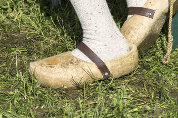 close up from a man's feet with traditional wooden clogs in a meadow
