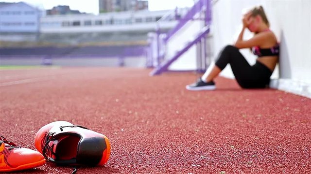 Teenager girl athlete taking breath tired exhausted disappointed after running on a stadium