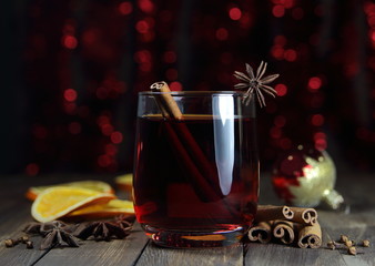 глинтвейн с корицей ,бадьяном и новогодним шаром на фоне праздничных огней
