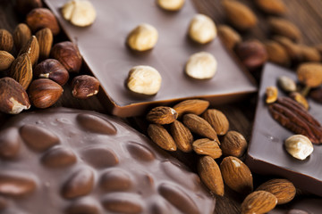 Dark homemade chocolate bars and cocoa pod on wooden