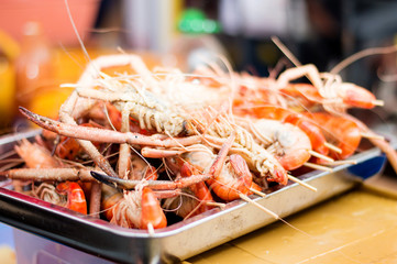 grilled shrimp in a tray on sale at a festival.