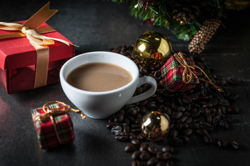 Obraz na płótnie Canvas Coffee cup and christmas toys with pine brench on black stone background.
