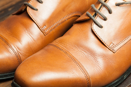 Men's leather shoes on a wooden floor